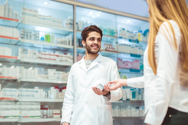 Опытный фармацевт консультирует женщину-клиента в современной аптеке
 - Фото, изображение