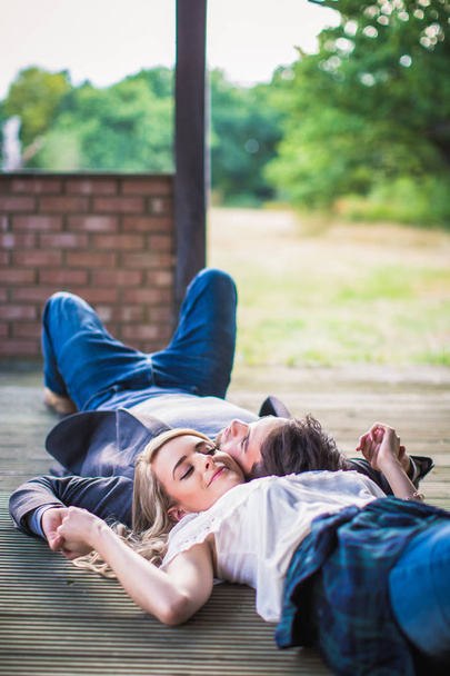 The young adorable couple in love lying head to head outdoor and smiling - Foto, afbeelding