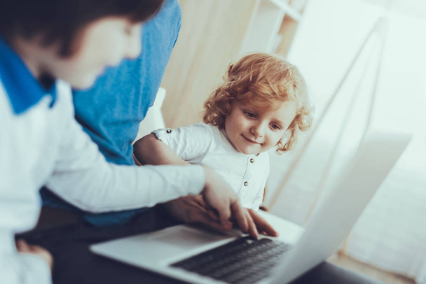Laptop. Technology. Show a Video. Family. Childhood. Happy Together. Leisure Time. Tablet. Spends Time. Smiling Kids. Father. Father Two Boys. Man. Smile. Home Time. Baby with Bright Hair. - Foto, Imagem
