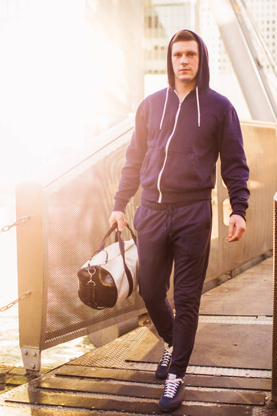 The young sporty man going with sporty bag outdoors - Foto, immagini