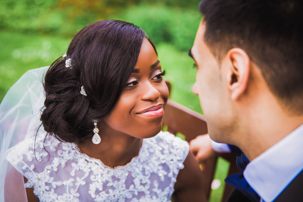 Portrait of young happy romantic newlyweds who looking at each other outdoors - Photo, Image
