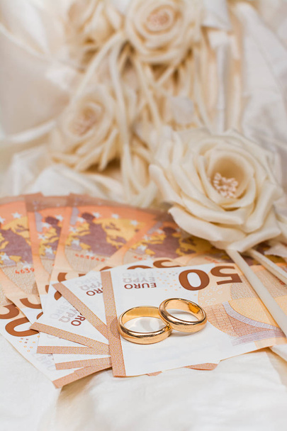 結婚指輪や背景にウェディング ドレスと紙幣 - 写真・画像
