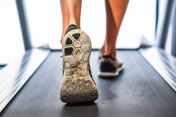 Pés musculares masculinos em sapatilhas correndo na esteira no ginásio. Conceito para fitness, exercício e estilo de vida saudável
. - Foto, Imagem