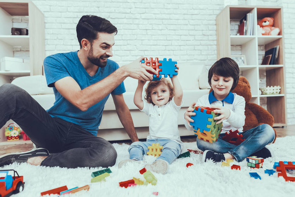 Smiling Kids. Father. Father Two Boys. Spends Time. Happy Together. Leisure Time. Man. Smile. Home Time. Baby with Bright Hair. Two Boys. Plays Games. Toys. Teddy Bear. Cars. Holidays. - Valokuva, kuva