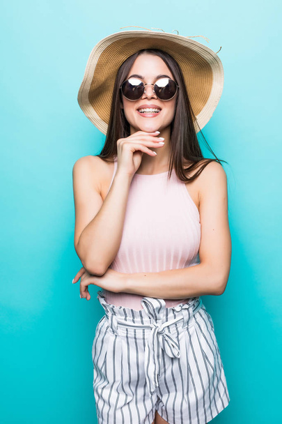 Mujer de viaje de verano en sombrero y gafas de sol listo para el viaje de fiesta y fiesta. Muchacha sonriente atractiva pensando en vacaciones
. - Foto, imagen