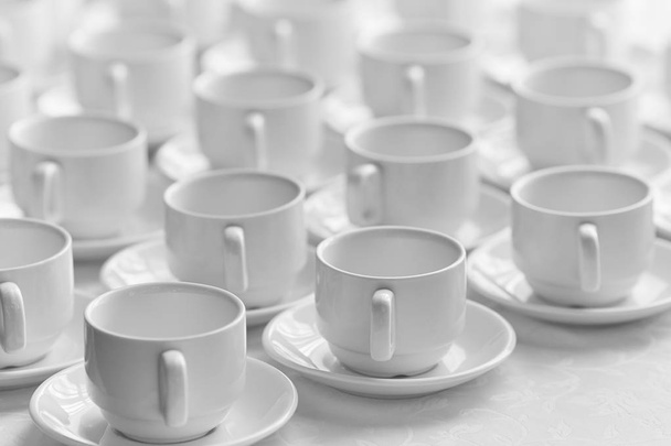 Vista superior en muchos apilados en filas de tazas blancas limpias vacías para el té o el café. Primer plano. Contexto
 - Foto, imagen