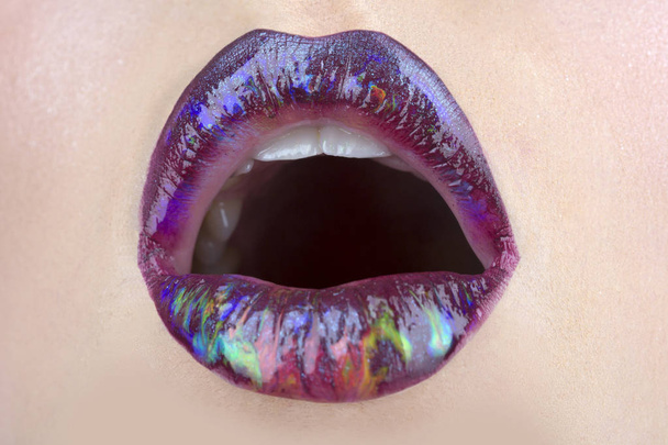 Ultra violet lipstick. Lips icon close up. A woman's mouth. Beautiful lips. Cosmetics concept. Brilliant lip gloss. Purple shiny lip gloss. Cosmetic products. Sensual sexy mouth - Photo, Image
