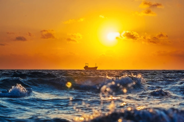 Грузовое судно на закате в Средиземном море
 - Фото, изображение
