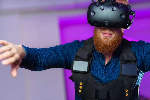 ein junger Mann mit rotem Bart spielt Virtual-Reality-Spiele - Foto, Bild