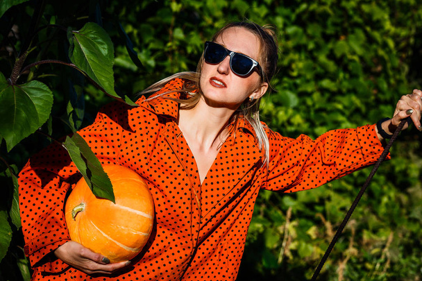 a young woman dressed for Halloween with pumpkin - Foto, afbeelding