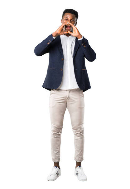 Corpo inteiro de belo homem afro-americano vestindo uma jaqueta gritando com a boca bem aberta no fundo branco
 - Foto, Imagem