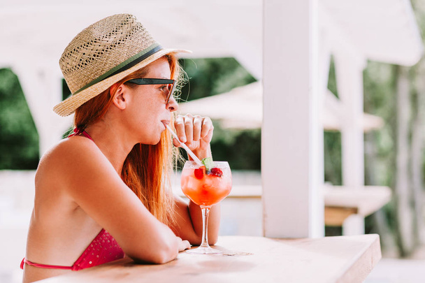 Jeune femme dégustant un cocktail dans un bar de plage
 - Photo, image