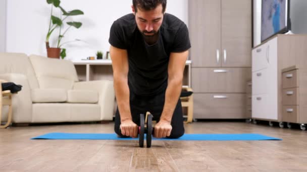 Deporte en casa - hombre en forma haciendo ejercicios con un ab whell
 - Imágenes, Vídeo