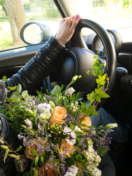 Bouquet of flowers in the hands of the driver - Foto, immagini