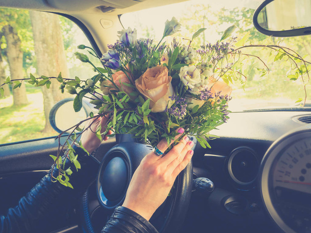 Buket çiçek sürücünün elinde. - Fotoğraf, Görsel