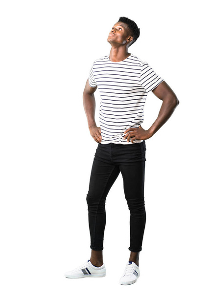 Full body of Dark skinned man with striped shirt standing and looking to the side on white background - Фото, изображение