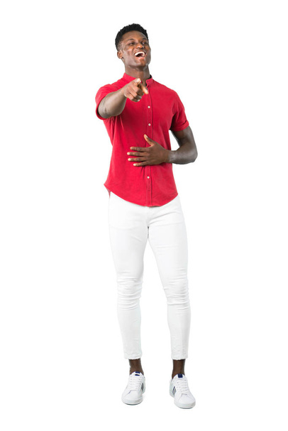 Full body of Young african american man pointing with finger at someone and laughing a lot on white background - Foto, imagen
