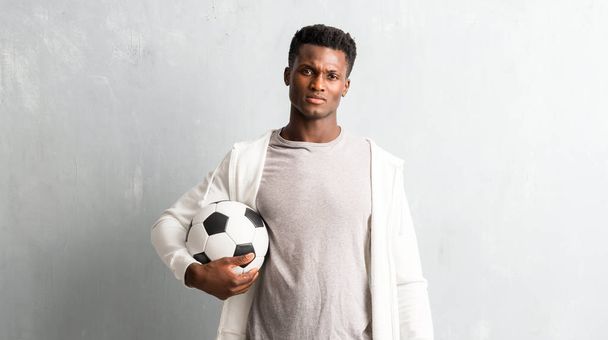 Afrikanischer amerikanischer Sportler in der Hand eines Fußballs - Foto, Bild