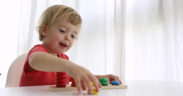 Kluk hraje s dřevěnými rozvíjející puzzle hračky - Záběry, video