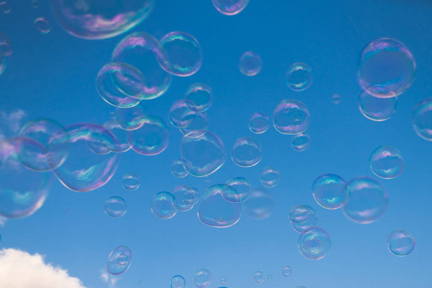 Burbujas de jabón gigantes flotando alto en el aire con el cielo azul en el fondo
 - Foto, Imagen