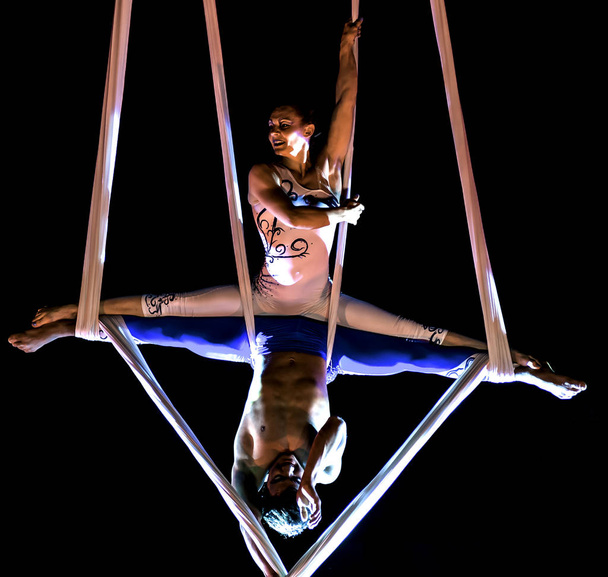 Bitonto, Italia - 28 maggio 2017: Gli acrobati eseguono un trucco sulle fionde sospese nel vuoto e fissate con imbracature in una serata festiva nella piazza principale di Bitonto, Puglia
 - Foto, immagini