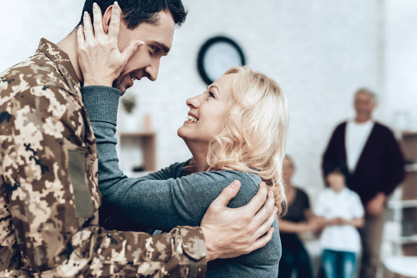 A Man Returns From The Military Service. Family Meeting. Leaving From War. Embrace With Family. Camouflage Uniform. Mom Hanging. Feelings Showing. Patriotic Comeback. Soldier Emotion. - Foto, Imagen