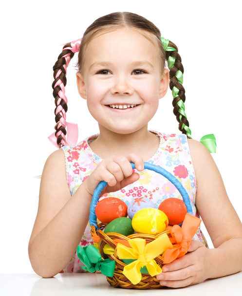 Little girl with basket full of colorful eggs - Фото, зображення