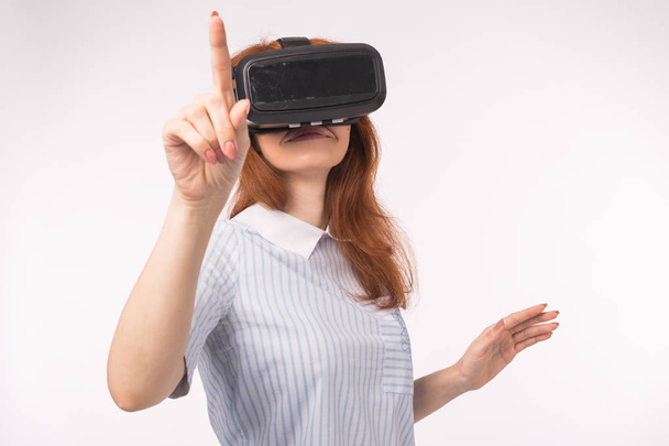 Fiatal vöröshajú nő segítségével a virtuális valóság szemüveg. - Fotó, kép