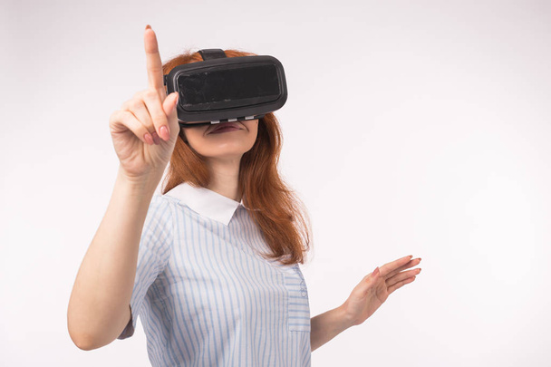 Mujer punto presionando la pantalla táctil por la realidad virtual sobre fondo blanco. VR gafas de auriculares concepto de dispositivo
 - Foto, Imagen