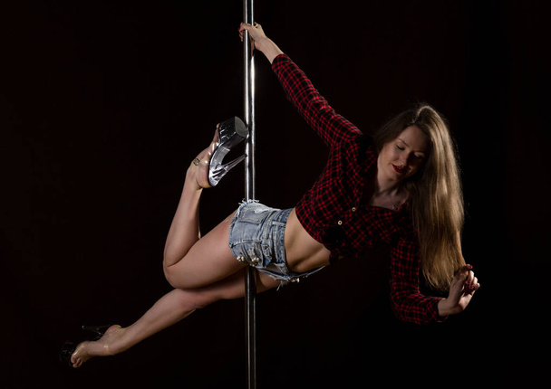beautiful go-go dancer in denim shorts and checkered shirt in night club. Pole Dance pin-up girl - Фото, зображення