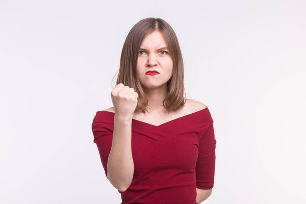 Portrait of angry young woman showing a fist on white background - Foto, Imagem