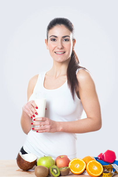 Nuori nainen, jolla on lasi maitoa valkoisella taustalla
 - Valokuva, kuva