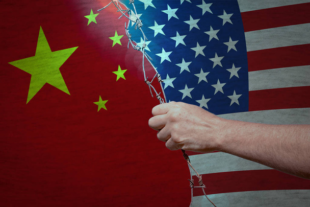 Wojna pomiędzy Usa i Chiny koncepcja handlu: Drut kolczasty w rękę pomiędzy amerykańskie i chińskie flagi - Zdjęcie, obraz