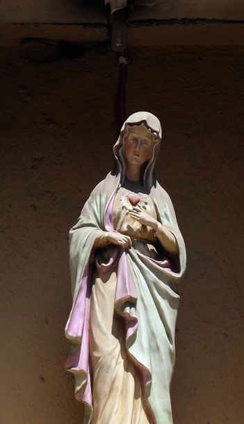 Statue de la Vierge Marie sur la porte d'entrée de la maison à Lucques, Toscane, Italie
  - Photo, image