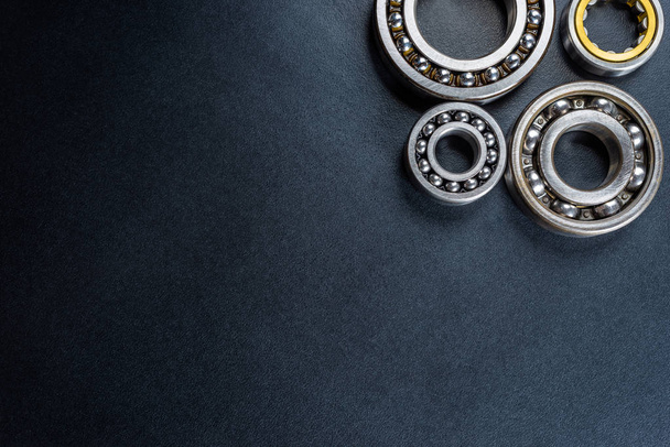 Ball bearing lying on a black background, flat view from above. - Photo, Image