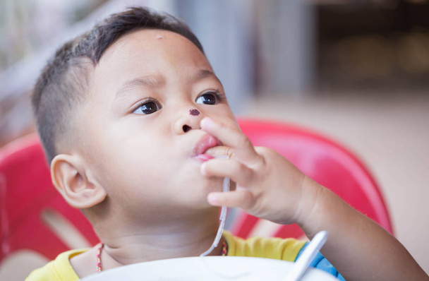 Το παιδί τρώει yummy τροφίμων. - Φωτογραφία, εικόνα