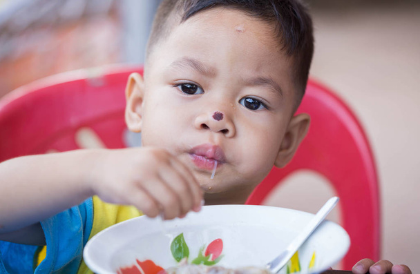 Το παιδί τρώει yummy τροφίμων. - Φωτογραφία, εικόνα