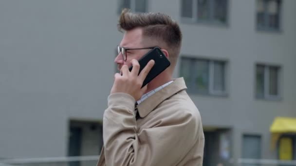 Cheerful businessman talking on his phone outdoors. - Felvétel, videó