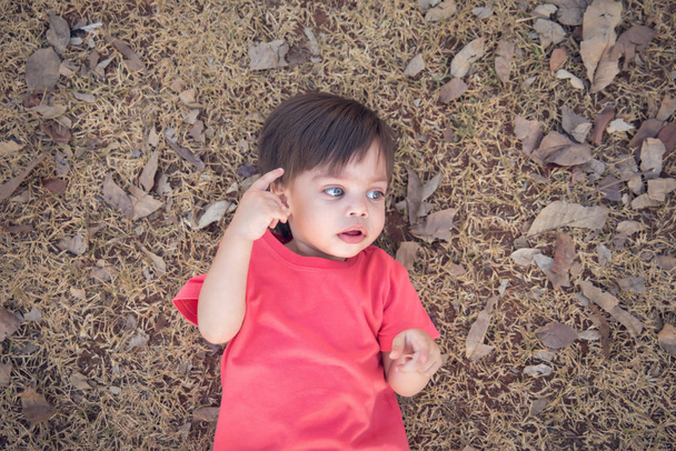 Niño lindo bebé - acostado sobre hierba seca
 - Foto, Imagen