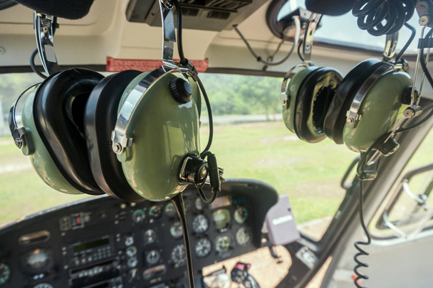 Auriculares del piloto de helicópteros montados en la cabina con el salpicadero
 - Foto, imagen
