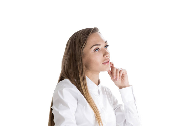 Side view of inspired young businesswoman with long fair hair wearing white shirt thinking about business challenge. Successful management concept. Isolated on white - Foto, afbeelding