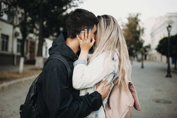 Vista lateral do belo casal apaixonado beijando na rua enquanto abraça
 - Foto, Imagem