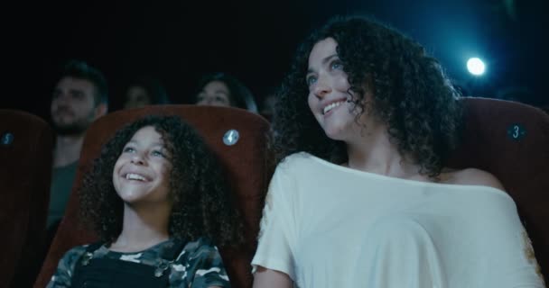 Onnellinen, nuori tyttö katsomassa elokuvaa äitinsä kanssa elokuvateatterissa
 - Materiaali, video
