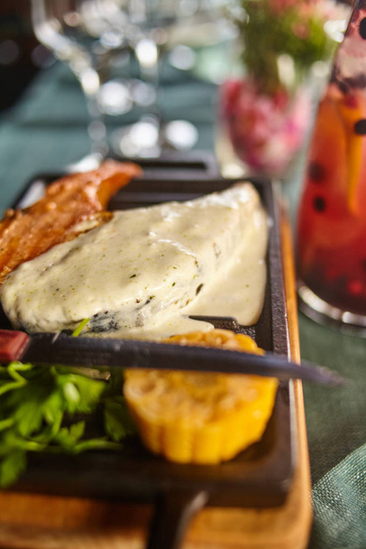 Filete de salmón con salsa y un decantador de una bebida de bayas
 - Foto, imagen