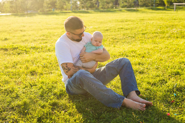 Onnellinen isä pitelemässä poikavauvaa luonnossa. Onnellisen perheen käsite, isien päivä ja lapsi
. - Valokuva, kuva