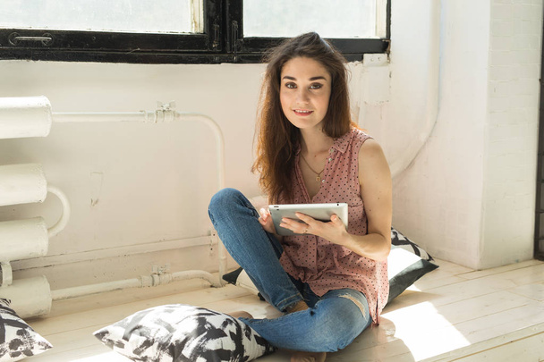 Internet, vapaa-ajan ja teknologian käsite - rento nuori nainen, joka käyttää tablettia
 - Valokuva, kuva
