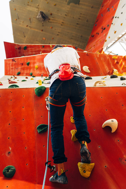 Człowiek wspinaczka na sztucznej ścianie wspinaczkowej w siłowni bouldering - Zdjęcie, obraz