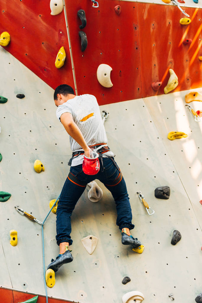 Handsome young man bouldering or rock climbing outdoors - Photo, Image