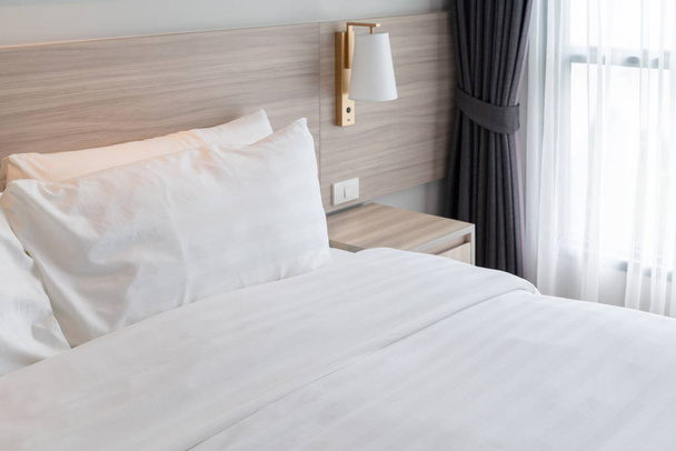 camera da letto moderna con letto in legno e set di cuscini in tono di colore bianco, concetto di decorazione d'interni
 - Foto, immagini