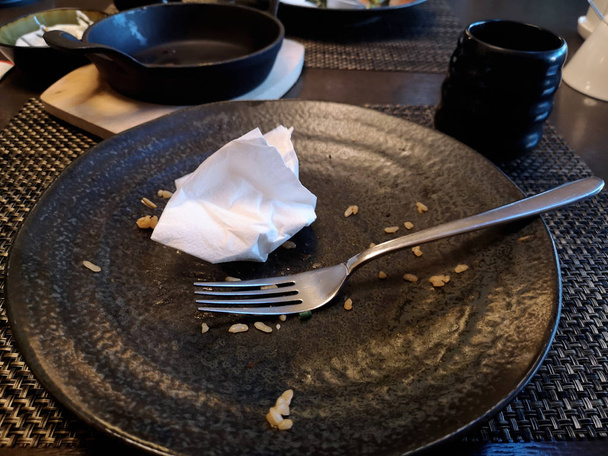 Порожня чорна тарілка на столі ресторану. Абстрактне фото
. - Фото, зображення
